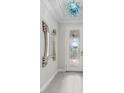 Elegant foyer features tiled floor, decorative mirror, stylish front door, and a blue glass chandelier at 5533 Long Shore Loop, Sarasota, FL 34238
