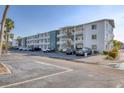 A condo complex showing the exterior elevation including car parking and tropical landscaping at 5891 Welcome Rd # I6, Bradenton, FL 34207