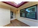 Well-lit front entry featuring a solid door with glass panel and a wooden porch at 6111 Courtside Dr # 61, Bradenton, FL 34210