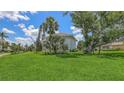 Beautiful home with a manicured lawn, mature trees, and vibrant landscaping creates a welcoming curb appeal at 670 Old Compass Rd, Longboat Key, FL 34228