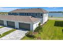 View of the rear of the property showing a two car garage and a well maintained lawn at 7352 Cabin Ln, Sarasota, FL 34240