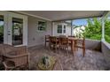 Cozy covered patio featuring brick flooring and charming wicker seating area at 7404 14Th W Ave, Bradenton, FL 34209
