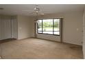 Bright living room with a ceiling fan and large window overlooking the front yard at 753 Tropical Cir, Sarasota, FL 34242