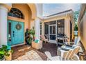 Inviting front patio with a light blue door, outdoor seating, grill, and stylish decor, creating a relaxing space at 7747 33Rd E St, Sarasota, FL 34243