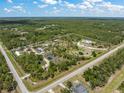 Aerial view of a large property with a home, pond, and various farm structures bordered by a road at 8146 Tropicaire Blvd, North Port, FL 34291