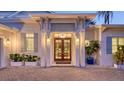Grand entrance with elegant double doors, beautiful plants, and a brick paver driveway at 1530 Pine Bay Dr, Sarasota, FL 34231