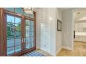 Bright foyer with double doors, shiplap accents, and hardwood floors at 1530 Pine Bay Dr, Sarasota, FL 34231