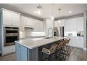 Modern kitchen with white cabinets, stainless steel appliances, and a large center island with seating at 16418 Slate Pl, Lakewood Ranch, FL 34211
