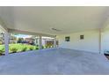 Open carport space showing the concrete flooring and providing covered parking with outdoor views at 2400 Lake Shore Dr, Nokomis, FL 34275