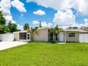 A charming home with a well-kept lawn and small palm trees in the front yard at 2416 Emory Ave, Bradenton, FL 34207