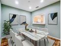 Elegant dining room with a modern marble table, stylish chairs, and contemporary artwork at 245 Cape Harbour Loop # 103, Bradenton, FL 34212