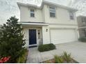 Inviting two-story home with a blue front door, attached two-car garage, and landscaped front yard at 2824 Rock Sound St, Bradenton, FL 34208