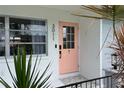 Close-up of the home's pretty pink front door flanked by plants and modern house numbers at 3011 Bougainvillea St, Sarasota, FL 34239