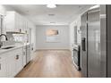 A bright kitchen with stainless steel appliances, white cabinets, modern hardware, and wood-look floors at 3236 Kingswood Dr, Sarasota, FL 34232