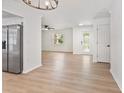 Open floor plan featuring wood-look floors, stainless steel appliances, and stylish lighting at 3236 Kingswood Dr, Sarasota, FL 34232
