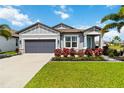 Charming single-story home with a manicured lawn, palm trees, and a gray two car garage at 3602 Quiet Dr, Sarasota, FL 34240