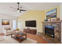 Cozy living room features a stone fireplace, vaulted ceiling with fan, and neutral decor at 4023 Hina Dr, Sarasota, FL 34241