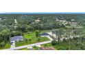 Wide aerial view of neighborhood with tree lined streets at 4148 Lobelia St, North Port, FL 34286
