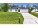 Charming single-story home features a well-manicured lawn and long driveway at 4148 Lobelia St, North Port, FL 34286