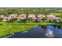 Aerial view featuring townhomes overlooking a beautiful lake with a fountain, and well-maintained landscaping at 4210 Vicenza Dr # D25, Venice, FL 34293