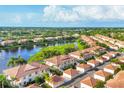 An aerial shot highlighting townhomes with terracotta roofs and a serene lake in a vibrant community at 4210 Vicenza Dr # D25, Venice, FL 34293