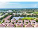 Stunning aerial view showcasing townhomes with terracotta roofs surrounding a scenic lake at 4210 Vicenza Dr # D25, Venice, FL 34293
