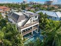 Aerial view of a modern home with multiple balconies, an outdoor spa, and a pool at 455 Cleveland Dr, Sarasota, FL 34236