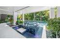 Outdoor lounge with a raised spa and tropical landscaping near the backyard pool at 455 Cleveland Dr, Sarasota, FL 34236