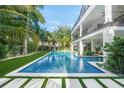 Backyard pool with turf and palm trees surrounding the exterior of the modern home at 455 Cleveland Dr, Sarasota, FL 34236