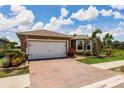 Home with brick driveway and landscaped front yard featuring mature landscaping at 5301 Shell Mound Cir, Punta Gorda, FL 33982