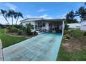 Home with colorful driveway, carport, mature landscaping, and exterior awning at 5402 Chateau Ln, Bradenton, FL 34207