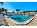 Community pool surrounded by palm trees and a white fence at 6016 Hibiscus Dr, Bradenton, FL 34207
