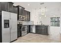Open kitchen with dark cabinets, stainless steel appliances, and seamless flow into the living area at 6454 Baytown Dr, Sarasota, FL 34240