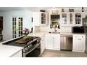 Bright kitchen with stainless steel appliances, white cabinetry, and a view to the yard through a french door at 6504 Heritage Ln # 99, Bradenton, FL 34209