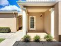 Inviting front entrance featuring decorative columns, manicured shrubs, and a well-lit porch for a welcoming appeal at 6604 7Th Avenue W Cir, Bradenton, FL 34209