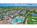 Stunning aerial view of the community's pool, tennis courts, and lush landscaping at 6918 Grand Estuary Trl # 104, Bradenton, FL 34212