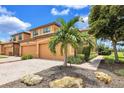 Inviting Mediterranean-style home with a paver driveway, two-car garage, and lush landscaping at 6918 Grand Estuary Trl # 104, Bradenton, FL 34212