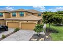 Inviting two-story home featuring a tile roof and manicured landscaping, enhancing its curb appeal at 6918 Grand Estuary Trl # 104, Bradenton, FL 34212