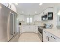 Modern kitchen with stainless steel appliances, granite countertops, and white cabinetry offers style and functionality at 726 Jungle Queen Way, Longboat Key, FL 34228