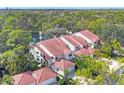 An aerial view of a condo community surrounded by lush landscaping with a pond and fountain feature at 7674 Fairway Woods Dr # 1605, Sarasota, FL 34238