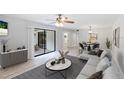 Open living room featuring a sliding glass door, modern furniture, ceiling fan and neutral paint at 814 Spring Lakes Blvd # 14, Bradenton, FL 34210