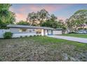 Charming single-story home with a gravel driveway, a green lawn, and fenced yard at 946 Charlotte Ave, Sarasota, FL 34237