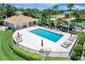 An outdoor community pool area surrounded by lush landscaping and comfortable lounging furniture at 1000 San Lino Cir # 1034, Venice, FL 34292