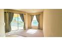 Bright living room with large windows offering scenic views and carpet flooring at 1251 Burgos Dr # 303, Sarasota, FL 34238