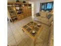 Cozy living room with comfortable seating, a beautiful display cabinet, and tile flooring at 1725 Briar Creek Ln, Sarasota, FL 34235