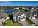 Stunning aerial view of the house with lush green lawn next to a serene lake in a vibrant community at 19293 Breynia Dr, Lutz, FL 33558