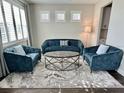 Inviting living room with stylish blue seating and a modern coffee table, perfect for relaxation and entertaining at 19293 Breynia Dr, Lutz, FL 33558
