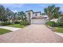 Gorgeous two-story home featuring a brick driveway, attached garage, and well-manicured lawn with mature landscaping at 19369 Nearpoint Dr, Venice, FL 34292