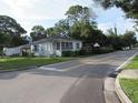 Inviting single-story home showcasing a quaint covered porch and lush greenery in a tranquil setting at 2102 Arlington St, Sarasota, FL 34239
