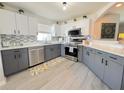 Modern kitchen featuring stainless steel appliances, gray cabinets, and a stylish backsplash at 2122 Pleasure Run Dr, Ruskin, FL 33570